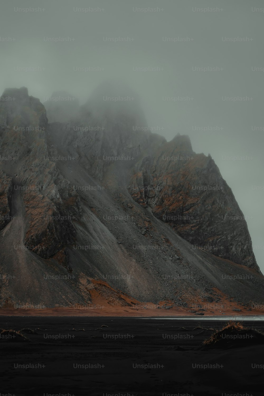 a mountain covered in fog on a cloudy day