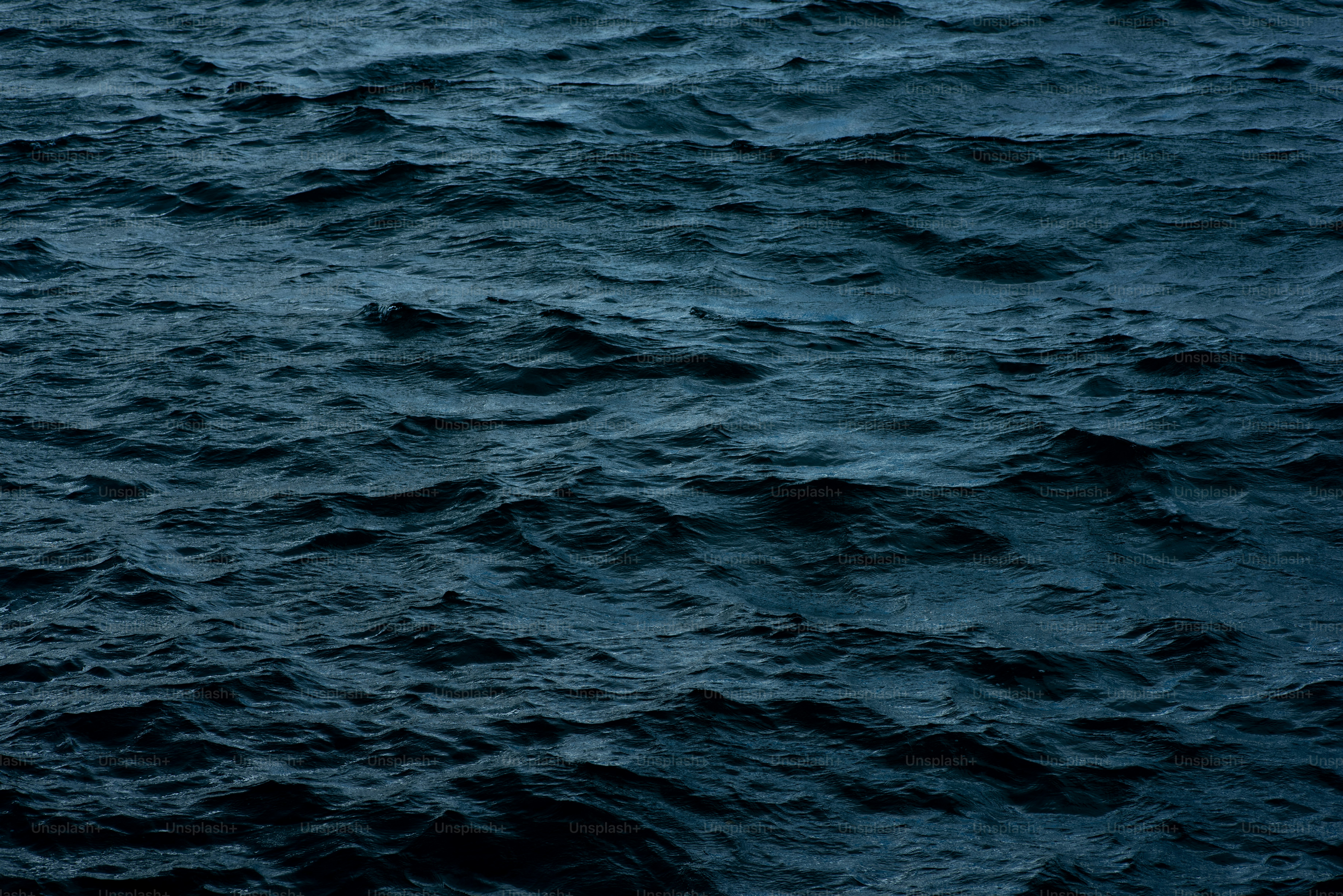 A large body of water covered in lots of dark blue water photo ...