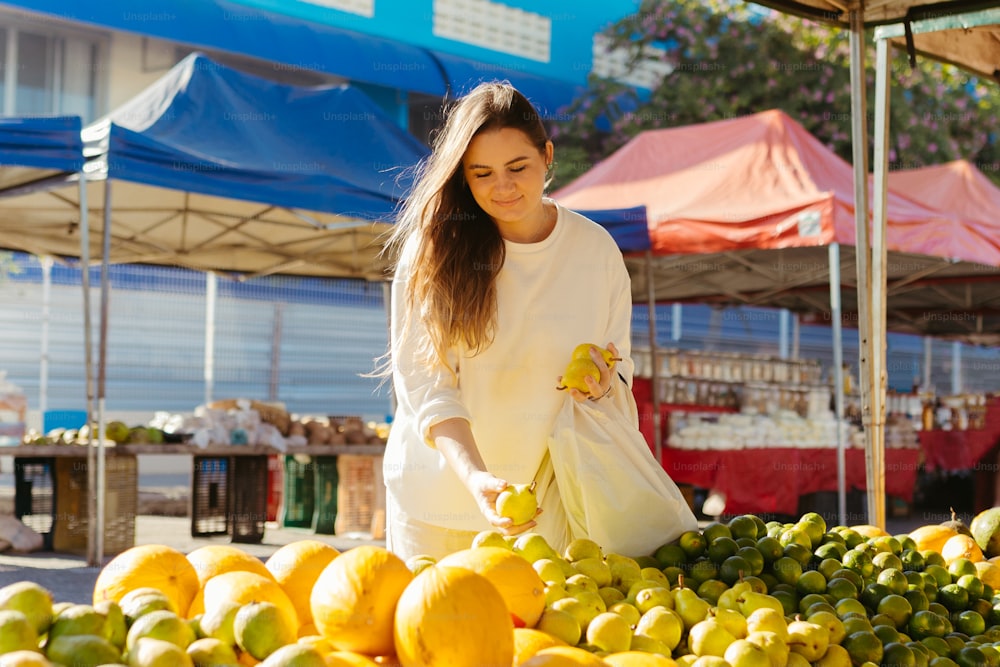 한 여자가 야외 �시장에서 과일을 쇼핑하고 있다