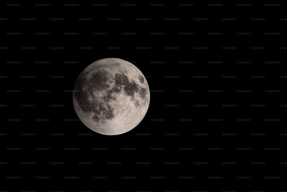 a full moon is seen in the dark sky