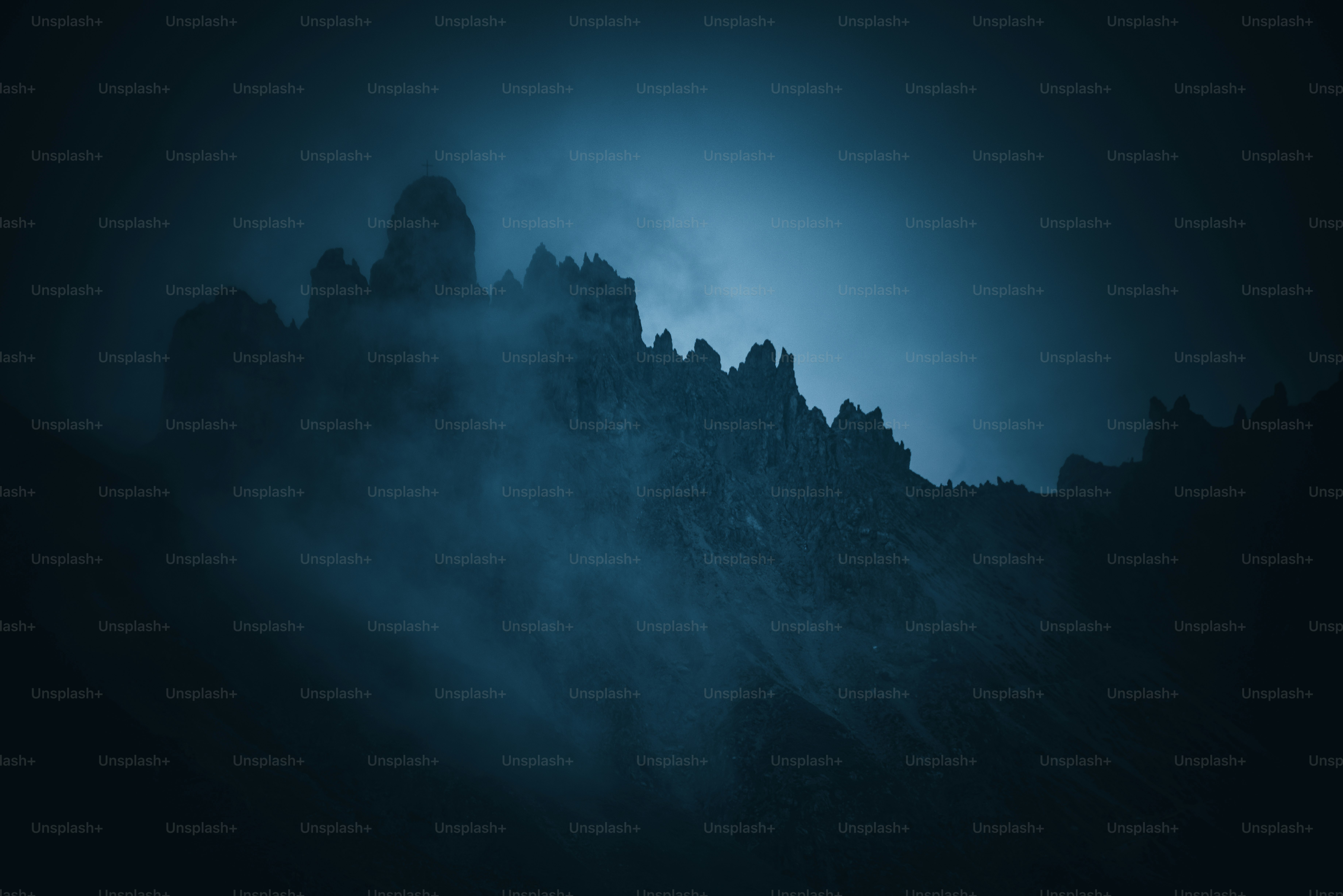 a very tall mountain in the middle of a foggy night