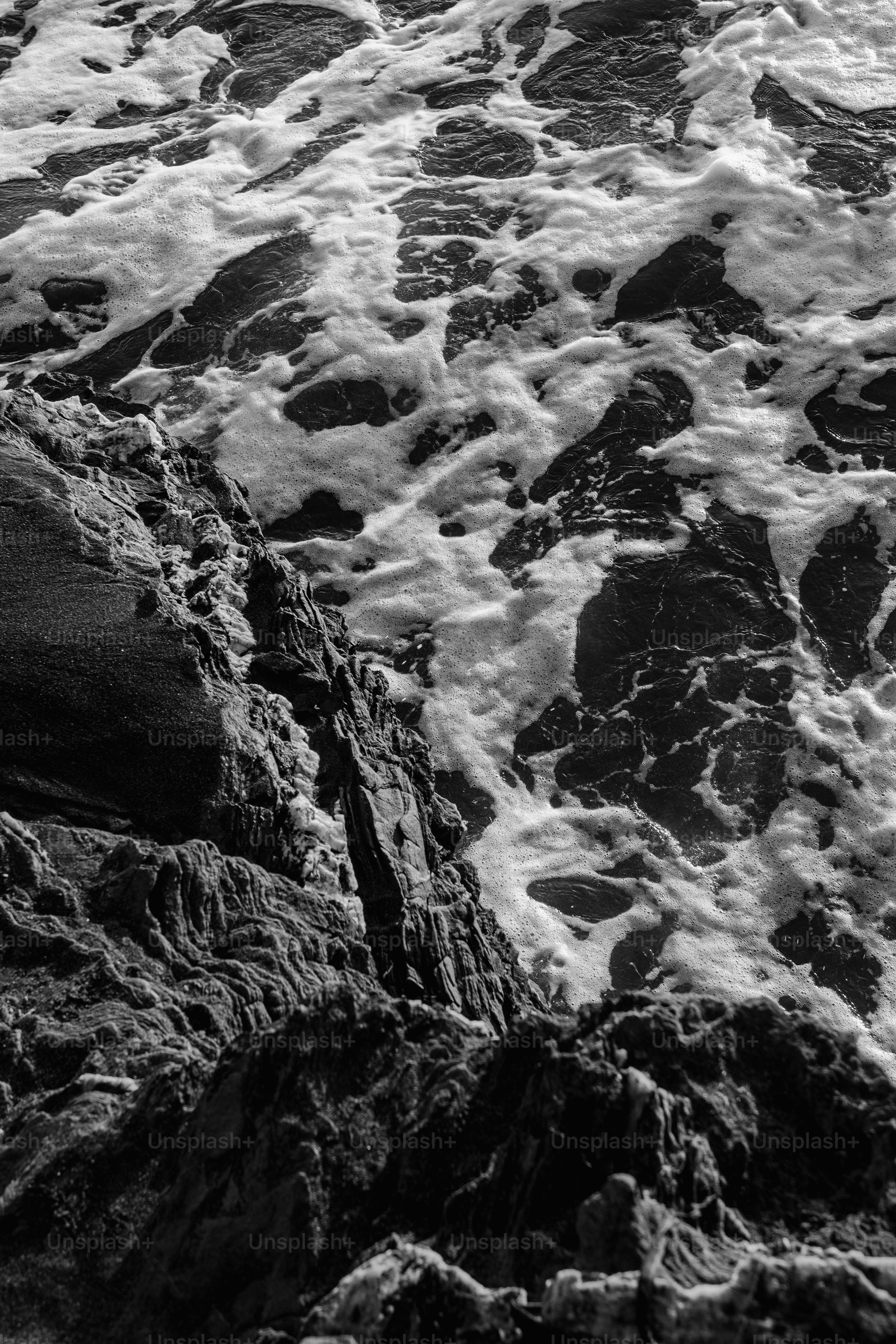 A black and white photo of waves crashing on rocks photo – Dark ...