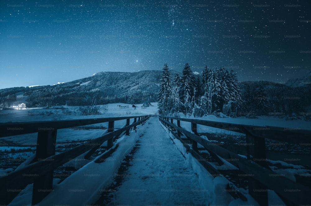 Ein verschneiter Pfad, der nachts zu einem Berg führt