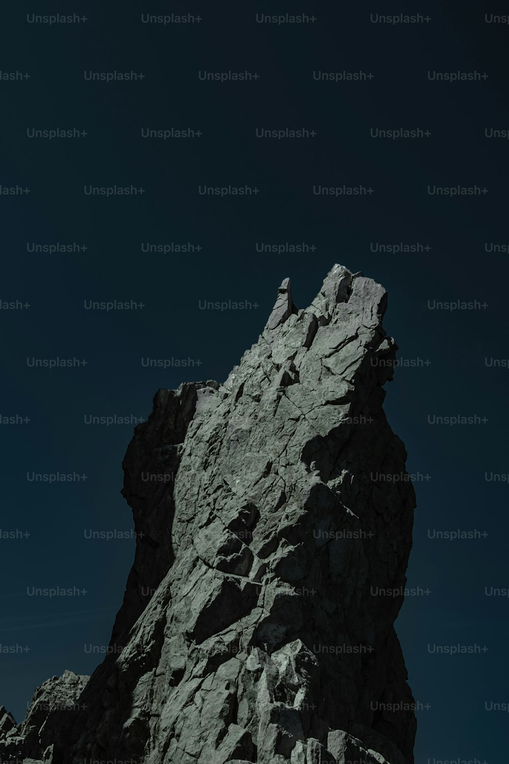 Una persona parada en la cima de una gran roca