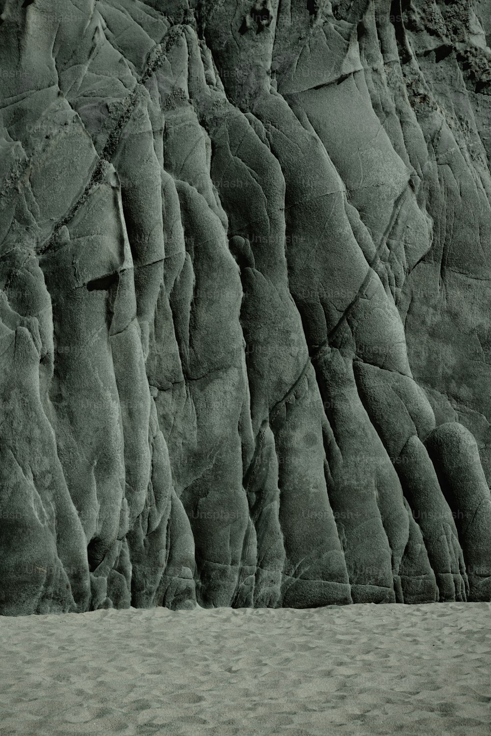 a black and white photo of a rock face