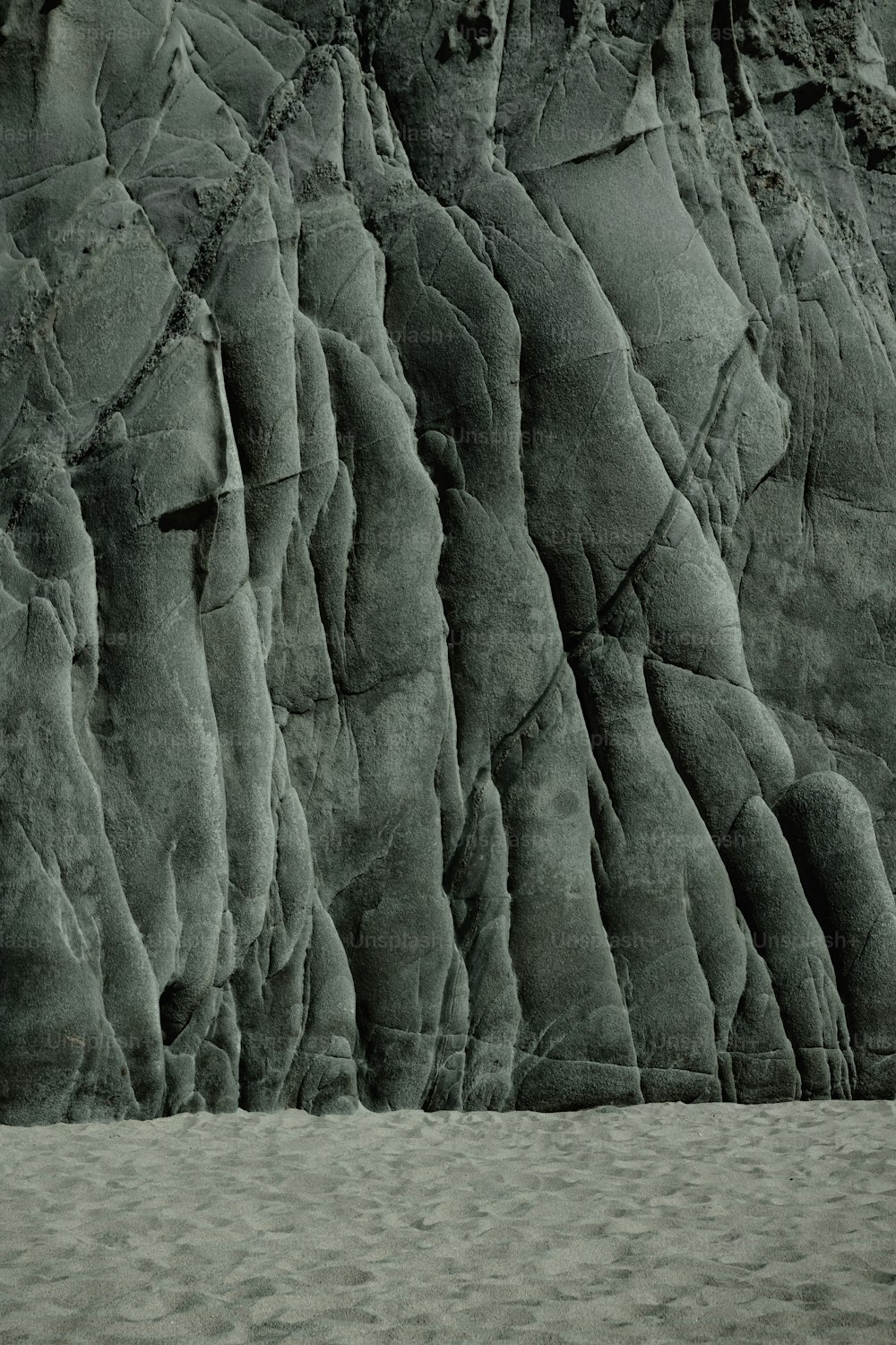 Una foto in bianco e nero di una parete rocciosa