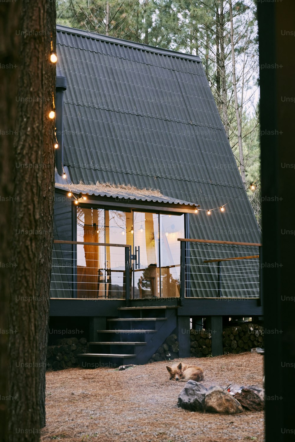 a small cabin with a deck and lights on the roof