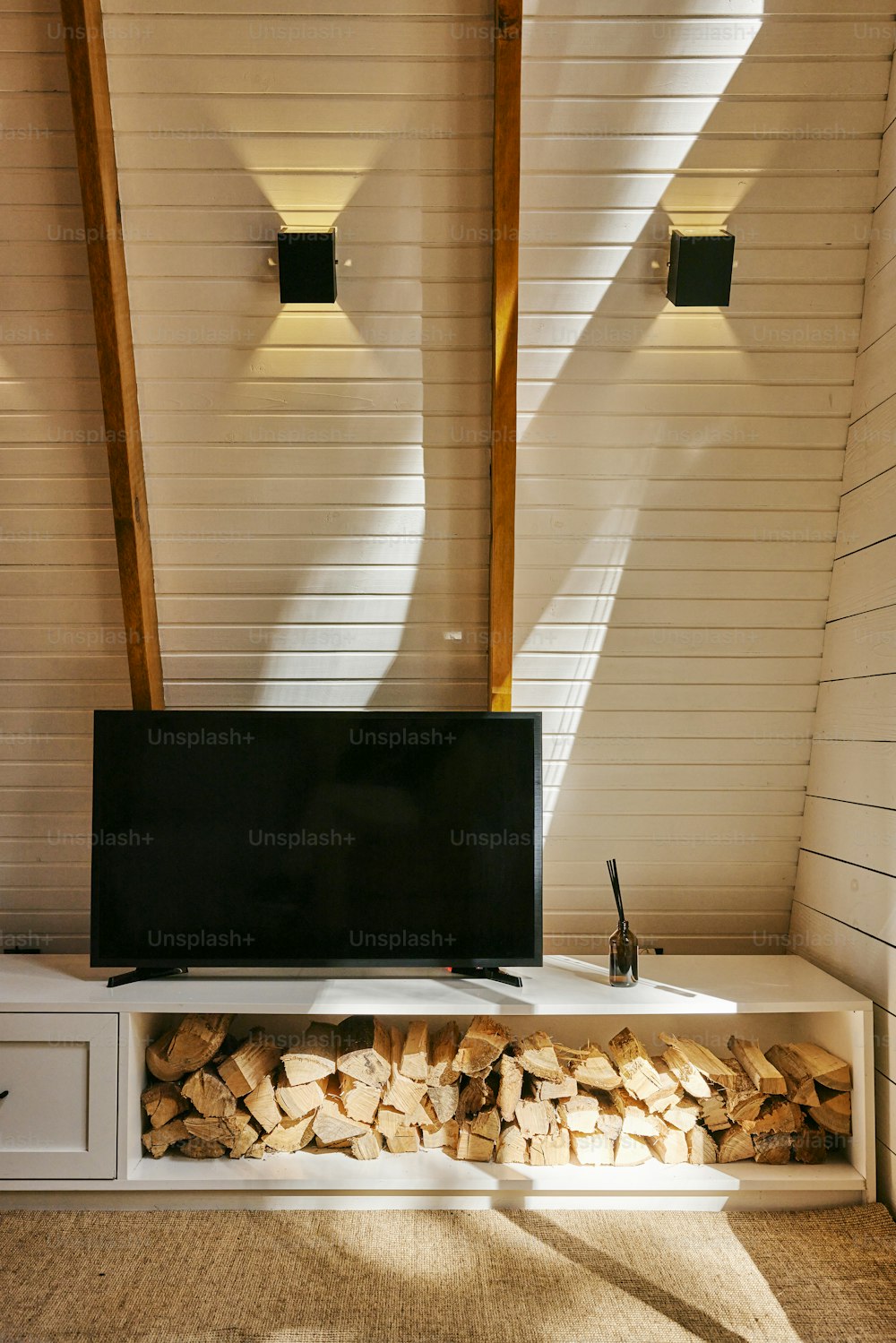 uma TV de tela plana sentada em cima de uma prateleira de madeira