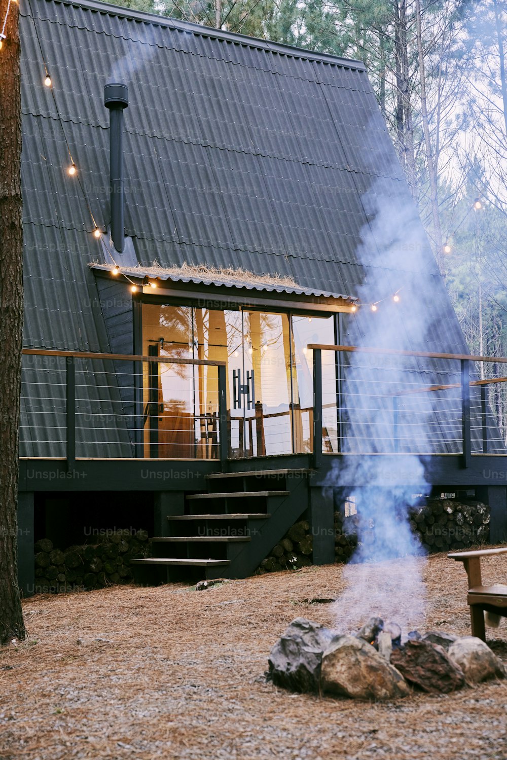 a house in the woods with smoke coming out of it