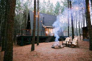 a small cabin in the woods with a fire pit
