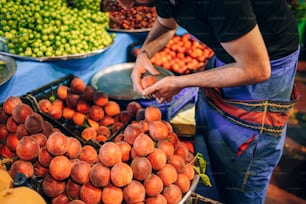 a man standing in front of a table filled with fruits