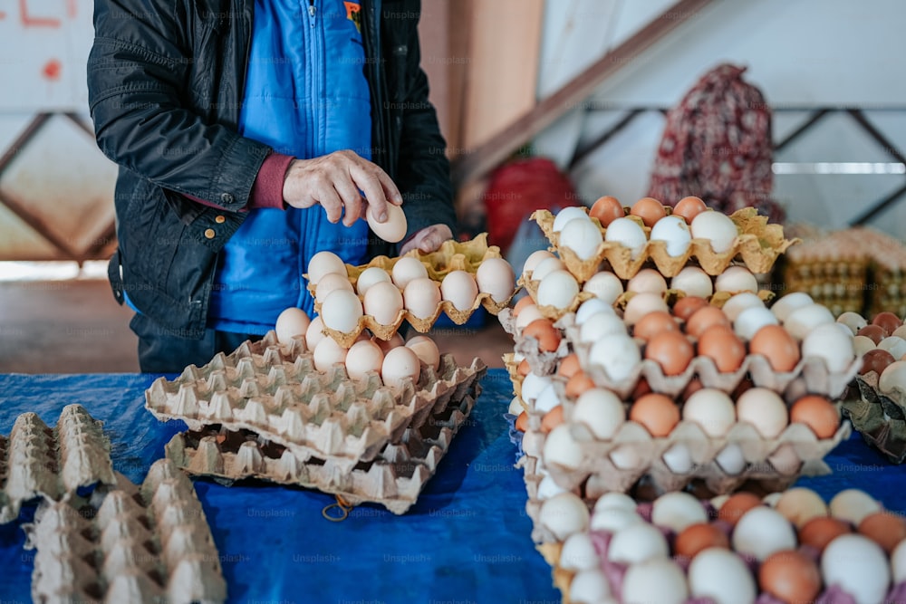 Un uomo in piedi davanti a un tavolo pieno di uova
