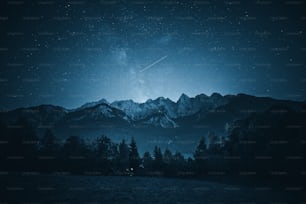 Un cielo notturno con stelle e una catena montuosa sullo sfondo
