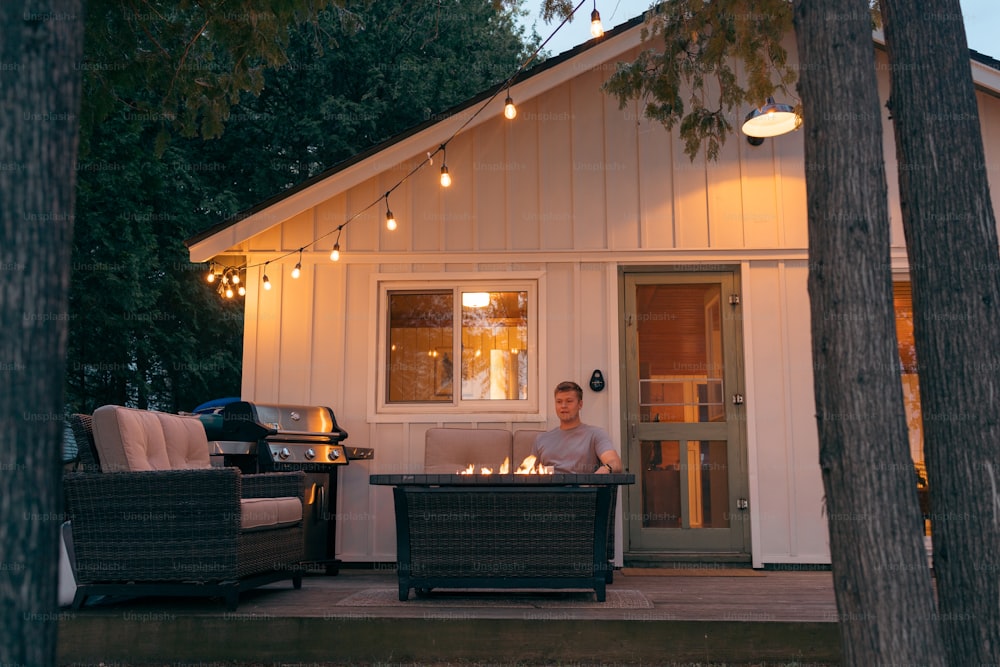 a man sitting on a couch in front of a house