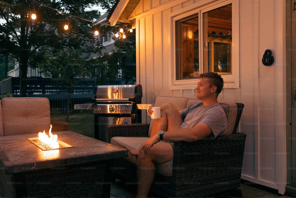 a man sitting in a chair next to a fire pit