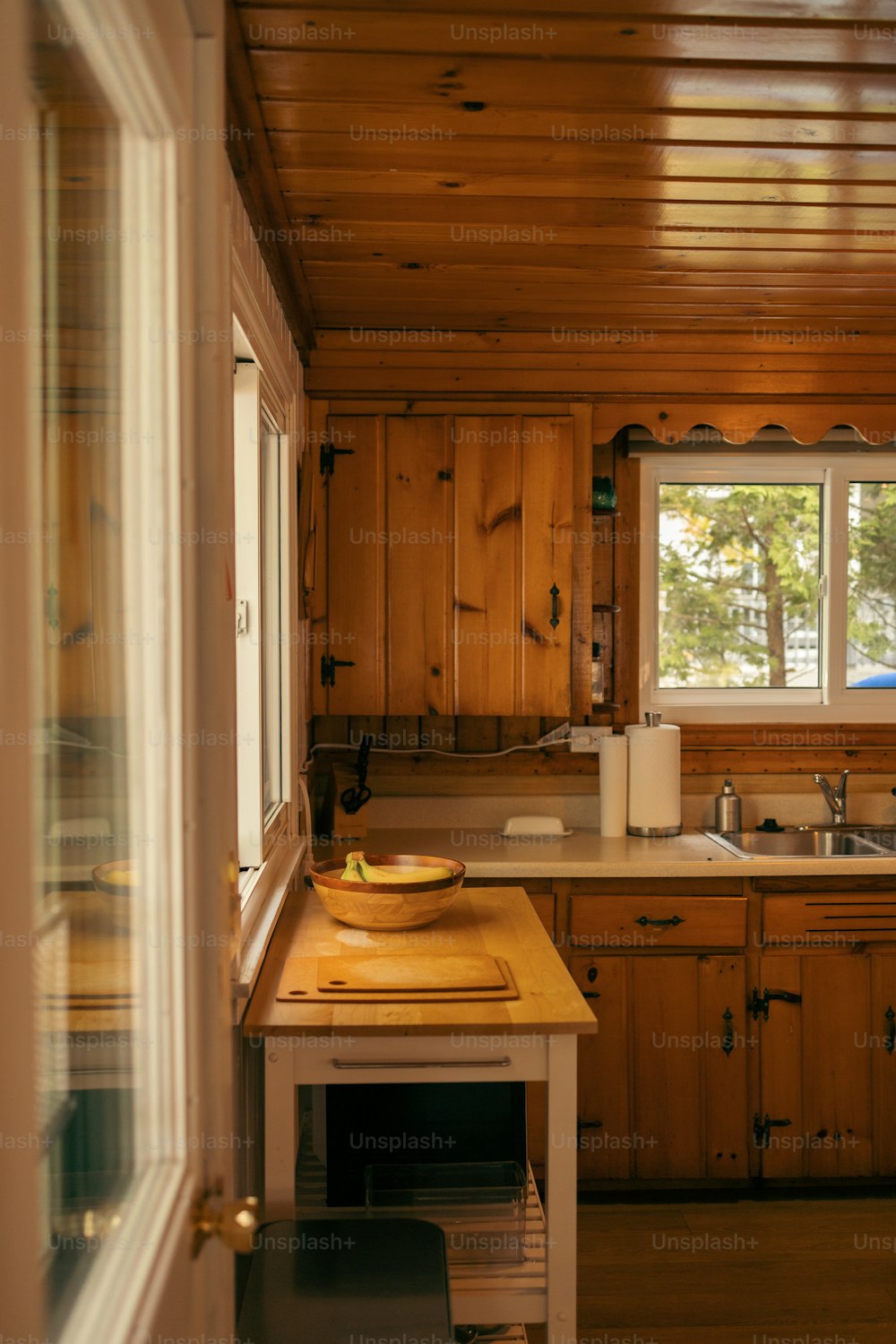 a wooden kitchen with a sink and a window