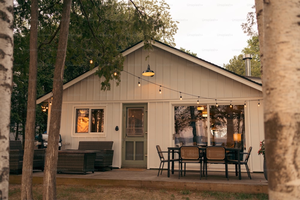 a small white house with a table and chairs outside