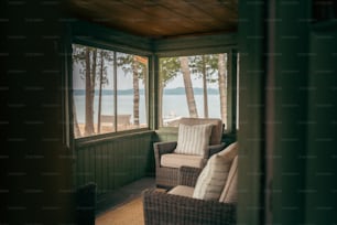 Una silla de mimbre sentada en un porche junto a una ventana
