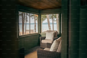 a wicker chair sitting on a porch next to a window