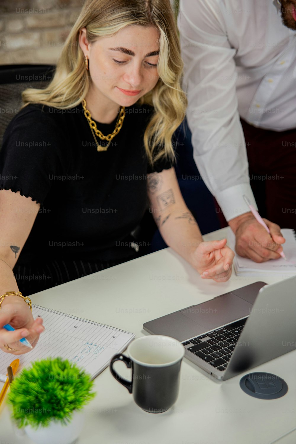 a woman sitting at a desk working on a laptop