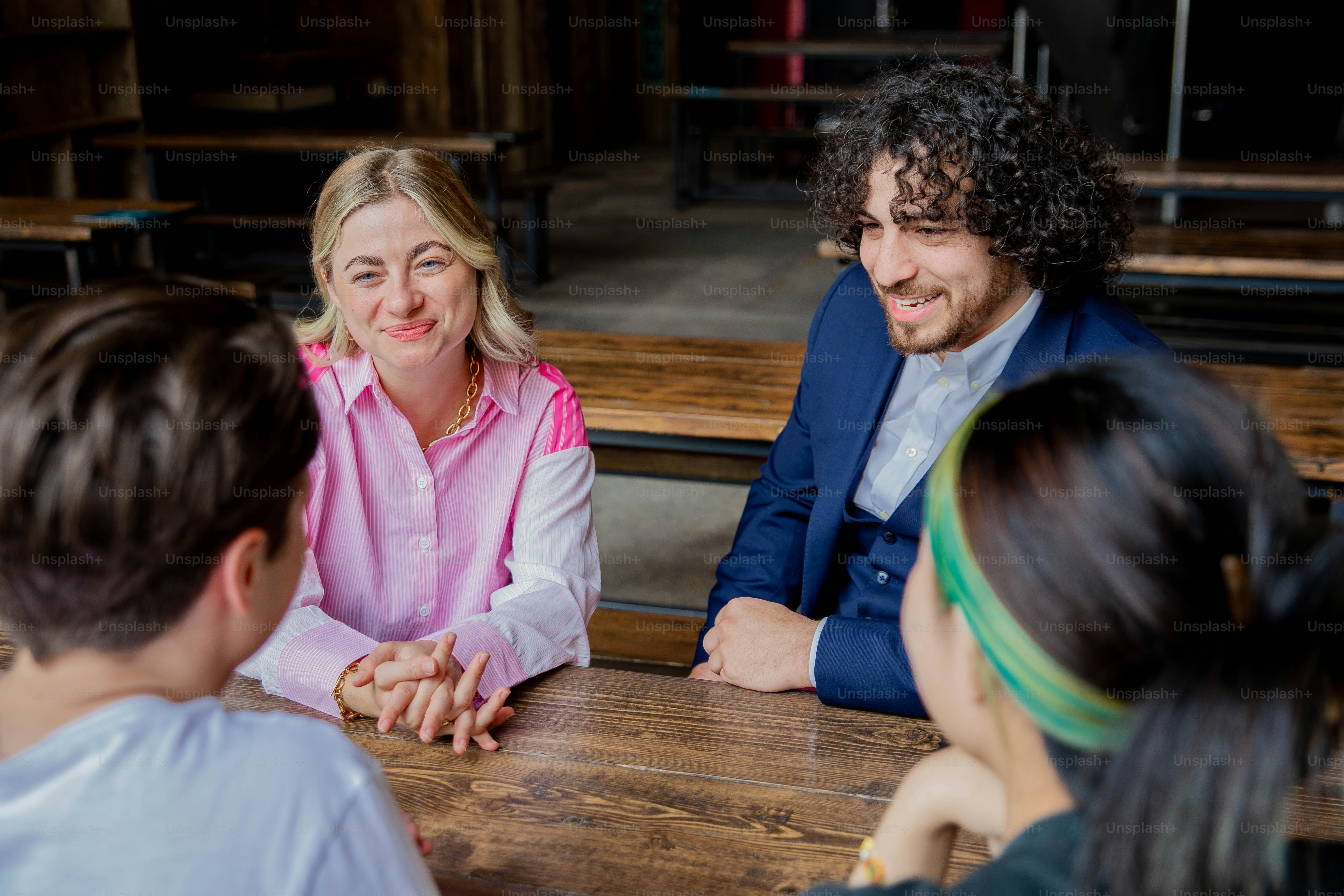 a group of people sitting around a wooden table