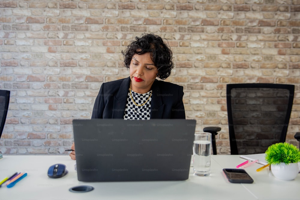 uma mulher sentada em frente a um computador portátil