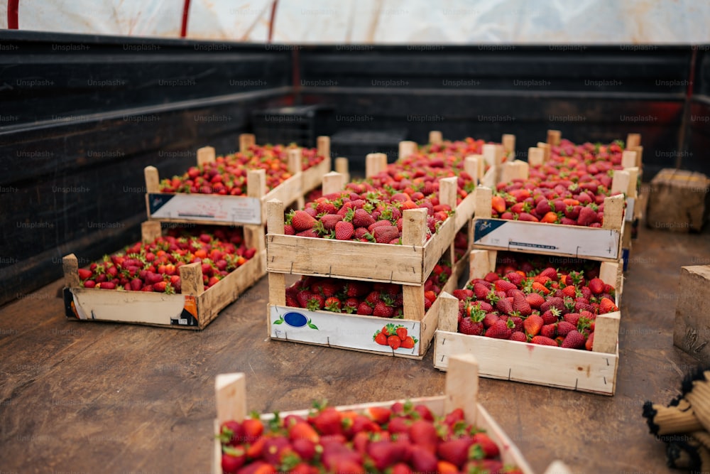 several crates of strawberries sit on a table