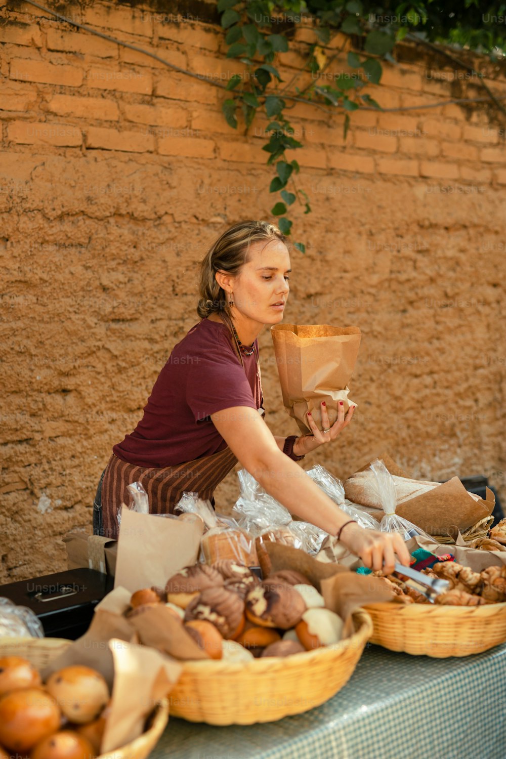 a woman sitting at a table with baskets of food