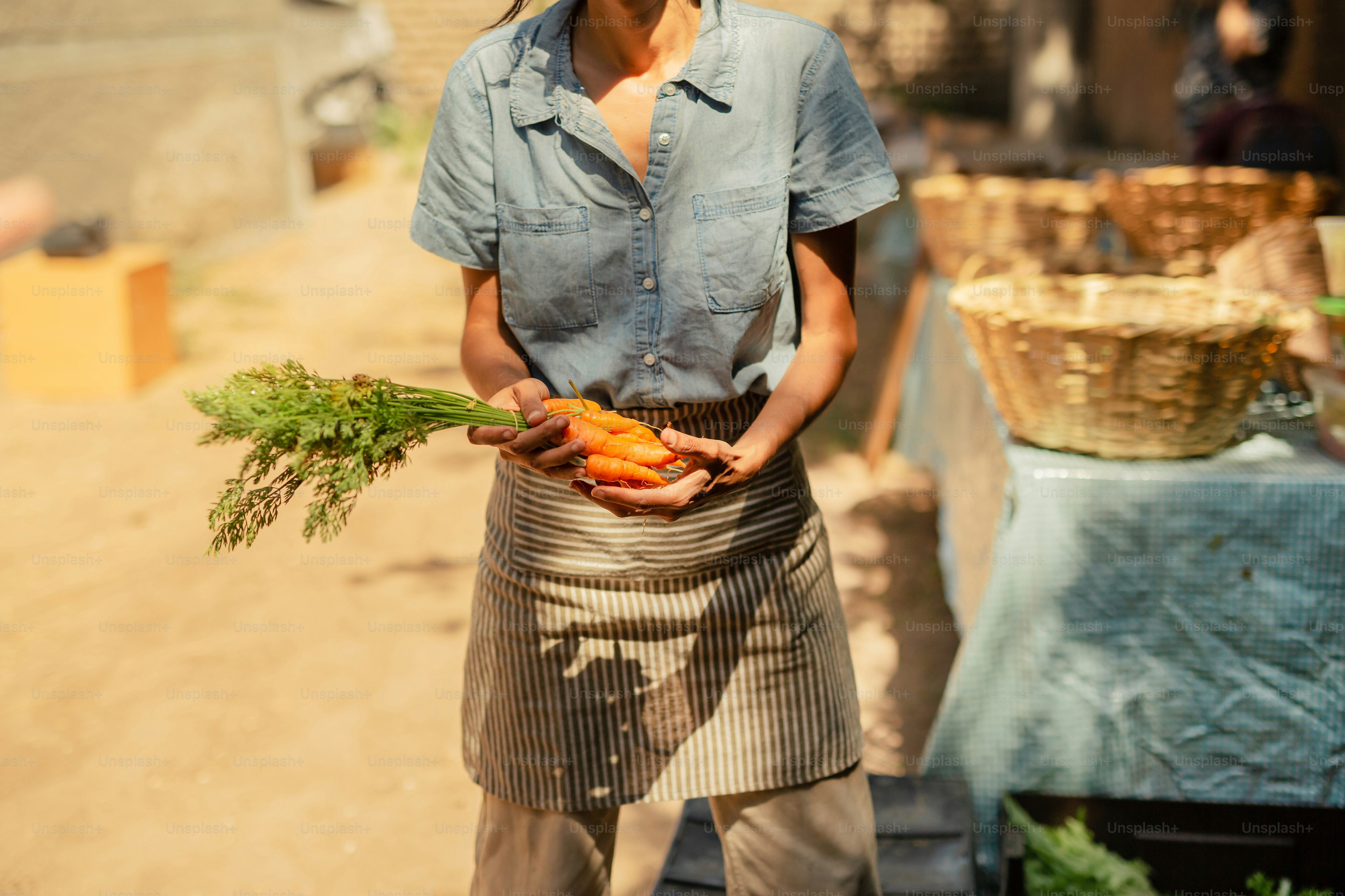a woman holding a bunch of carrots in her hands