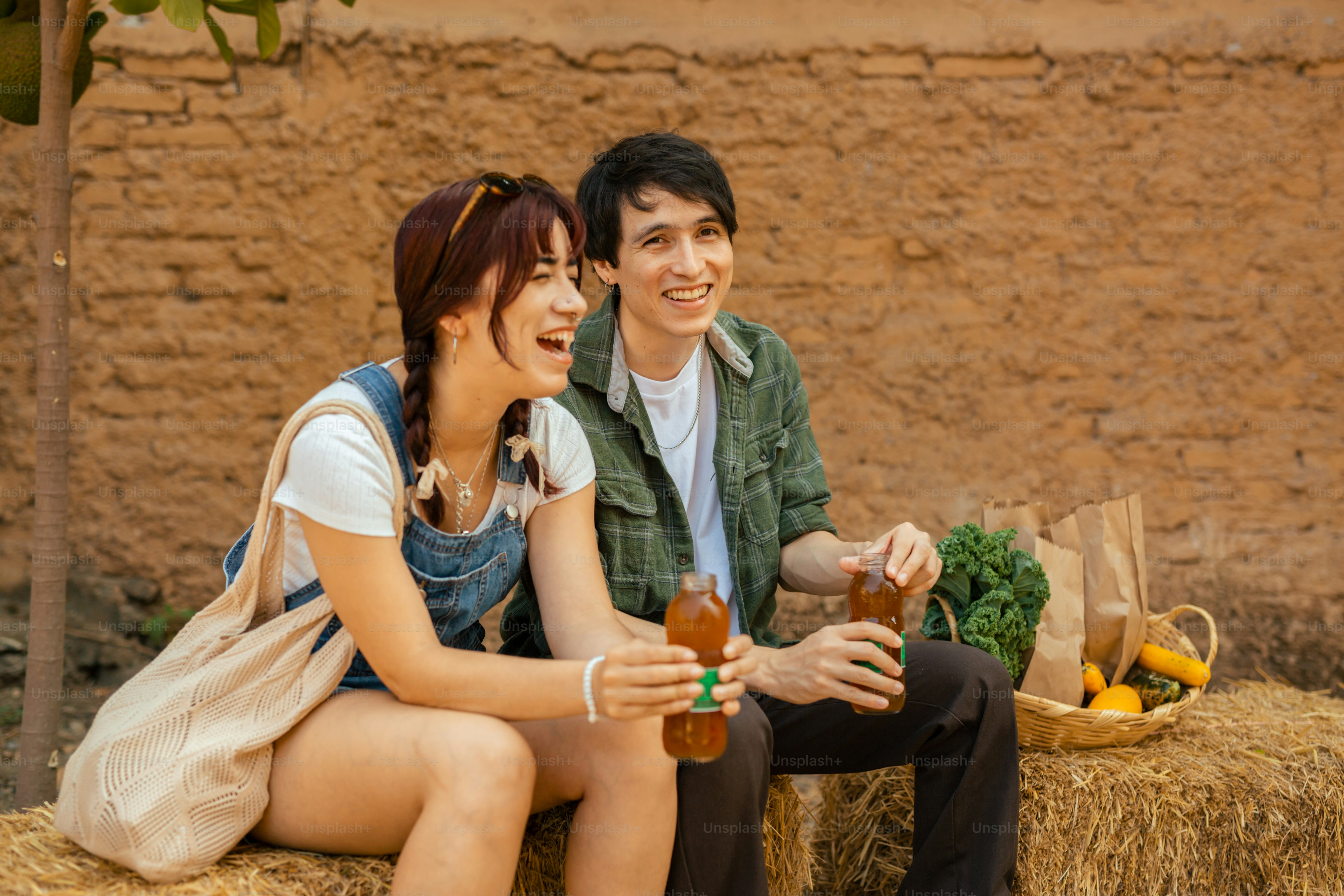 Un uomo e una donna seduti su una balla di fieno