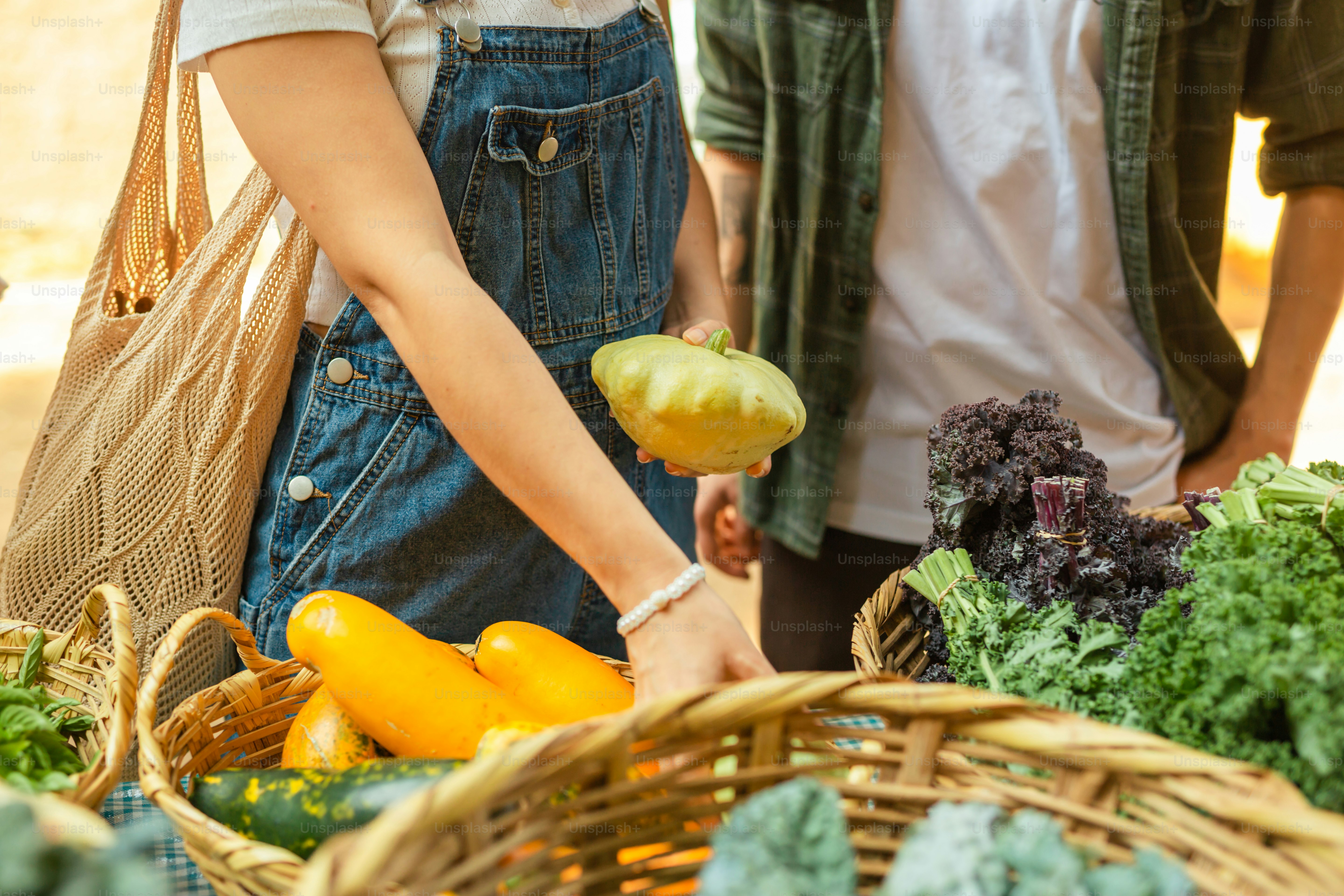 a man and a woman standing next to a basket of vegetables