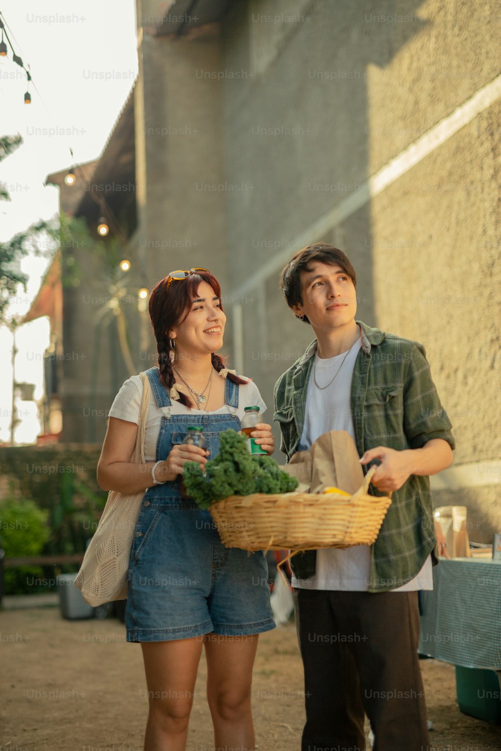 a man and a woman holding a basket of vegetables