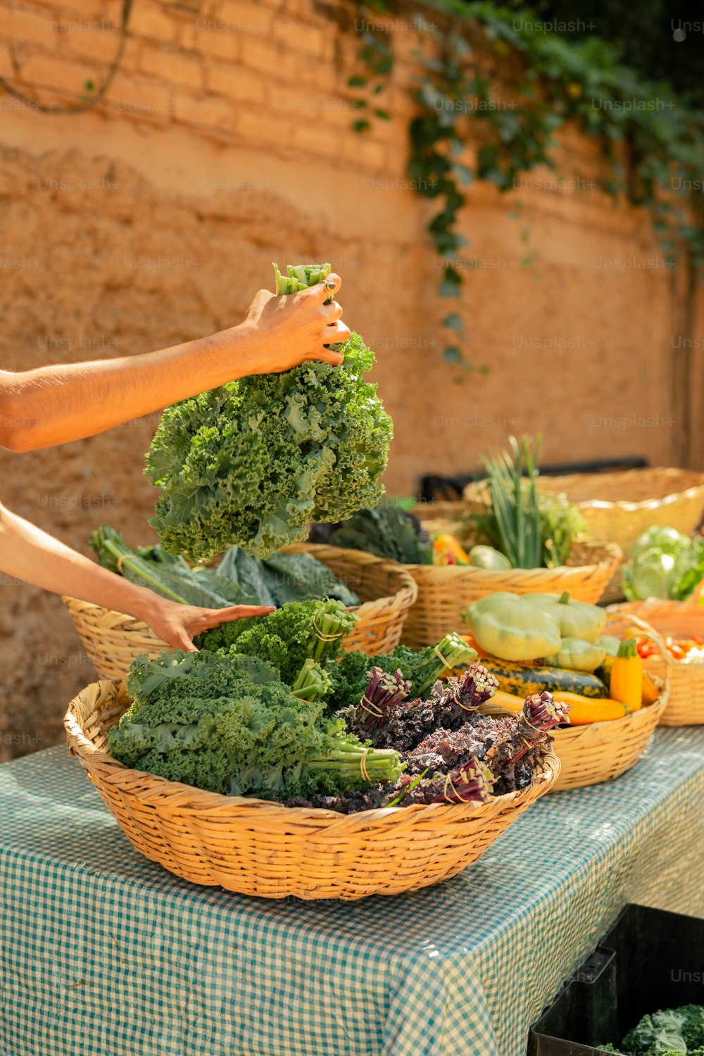 a person reaching for broccoli in a basket on a table
