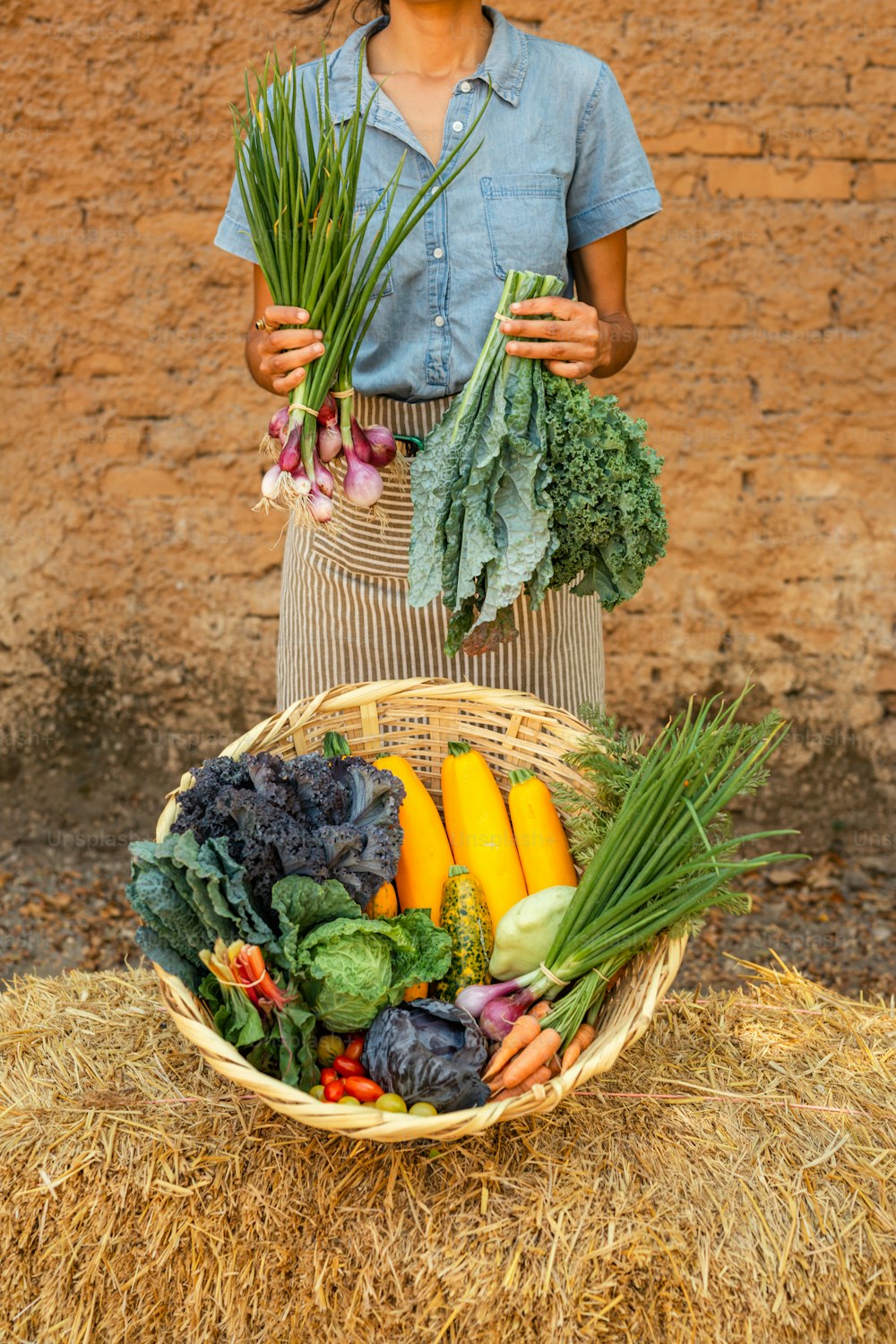 Una mujer sosteniendo una canasta llena de verduras