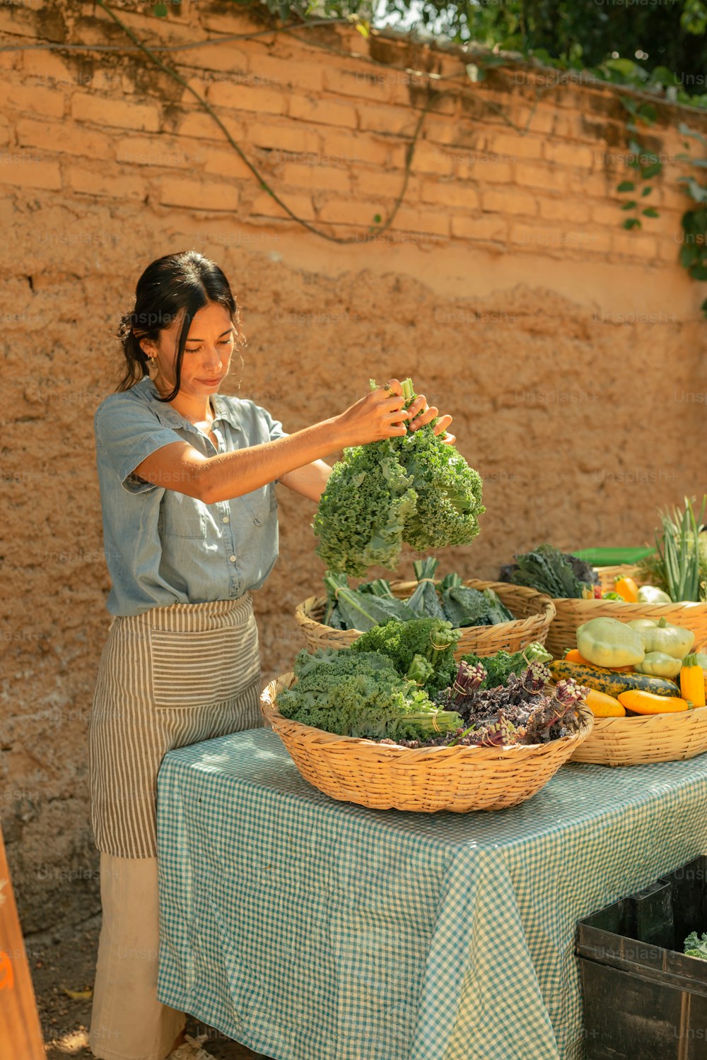 a woman standing next to a table filled with vegetables