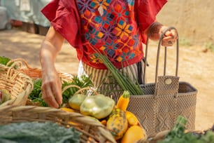 Una mujer de pie junto a una canasta de verduras