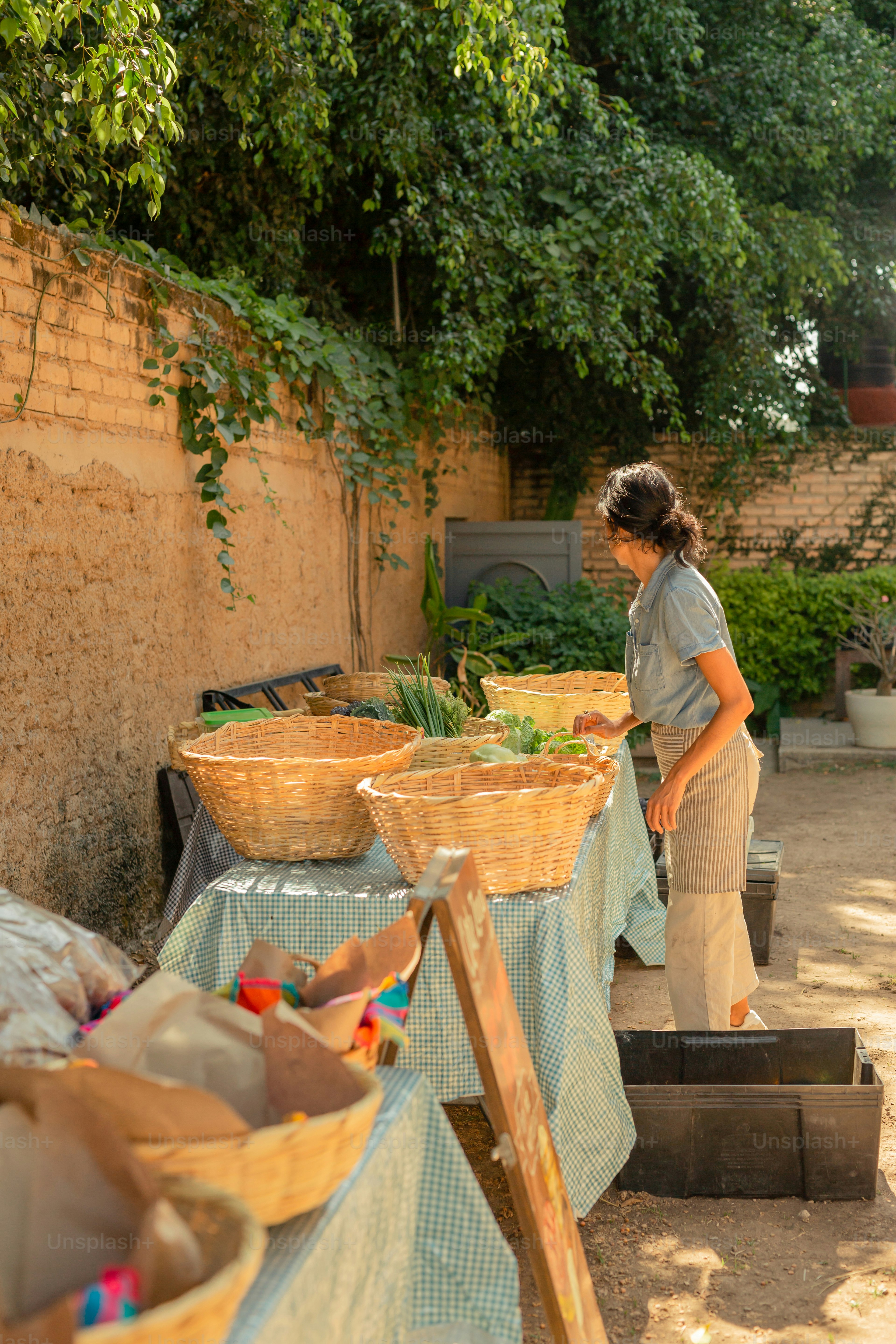 a woman standing next to a table filled with baskets