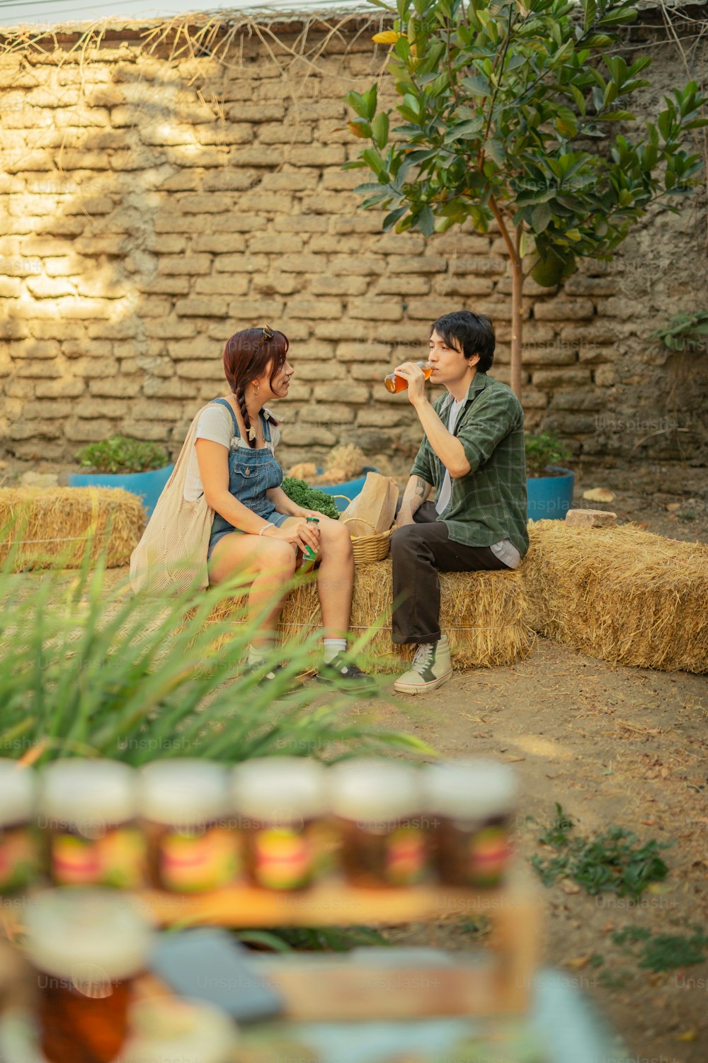 a man and a woman sitting on a hay bale