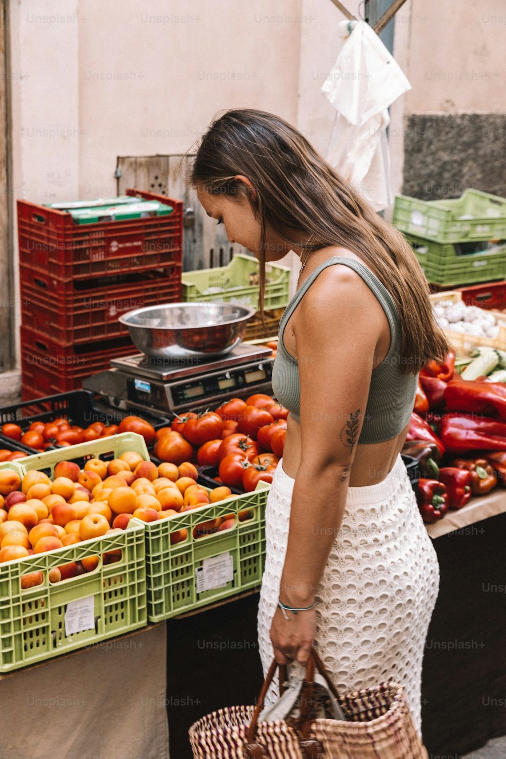 Une femme debout devant un stand de fruits