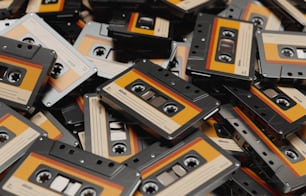 a pile of orange and black cassettes sitting on top of each other