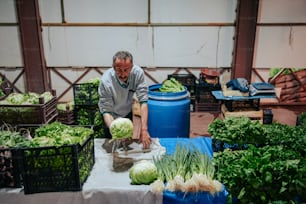 Ein Mann, der auf einem Bauernmarkt eine Wassermelone schneidet