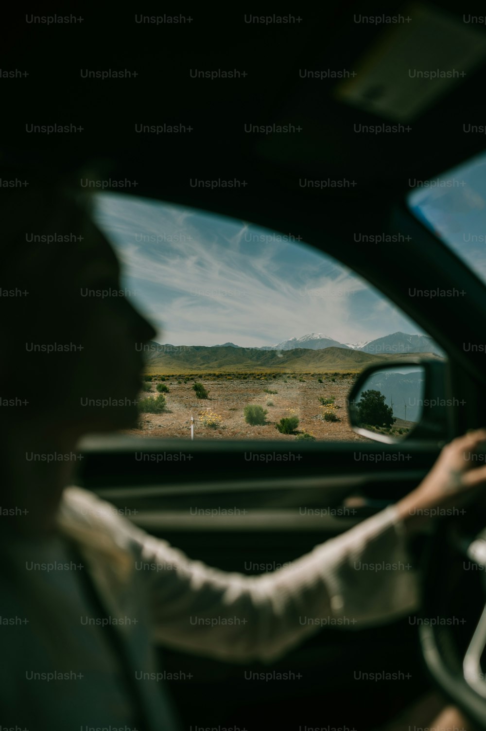 a man driving a car on a dirt road