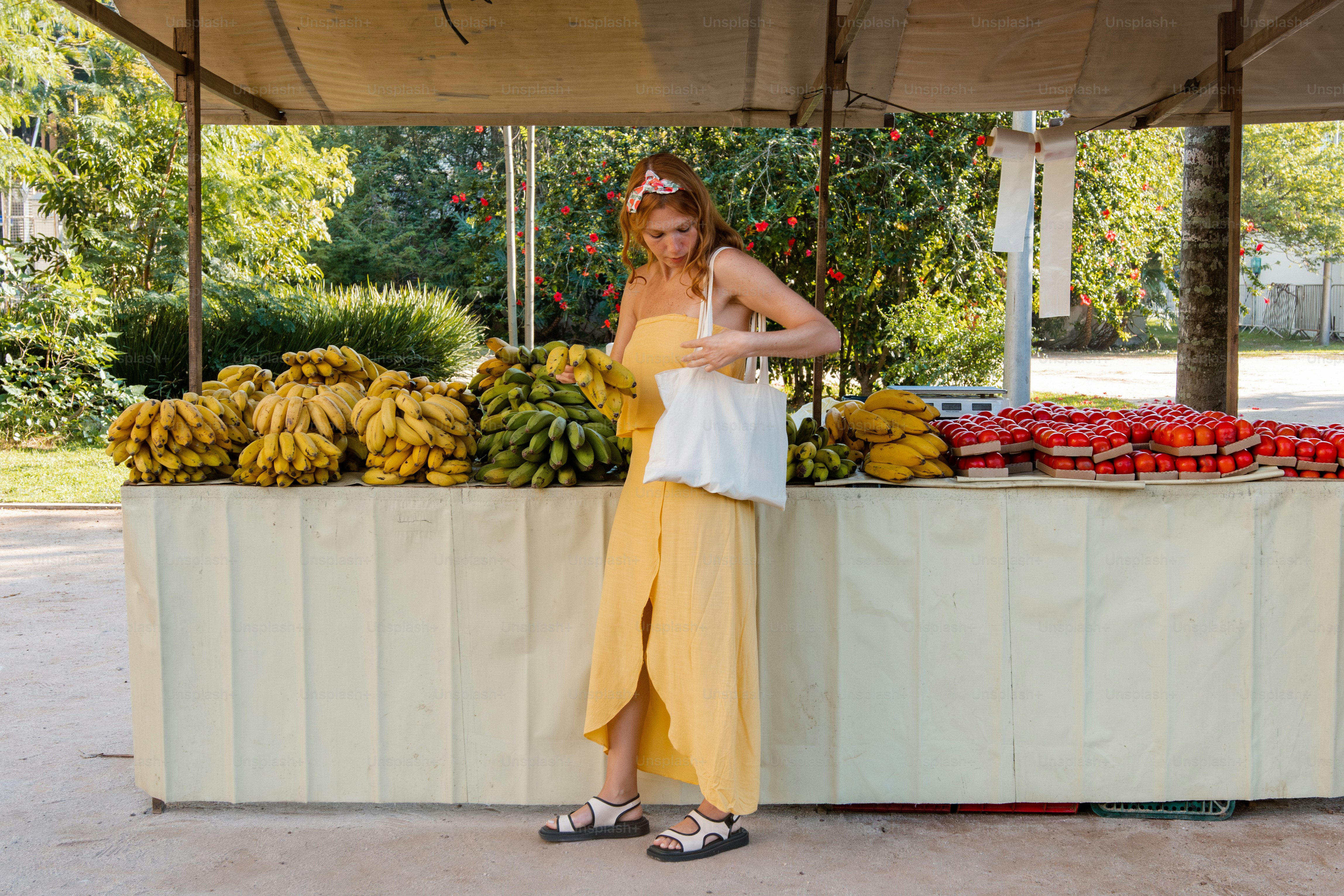 a woman standing in front of a fruit stand