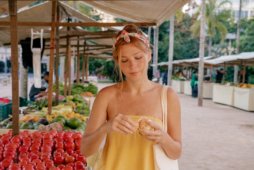 uma mulher em pé em frente a uma banca de frutas
