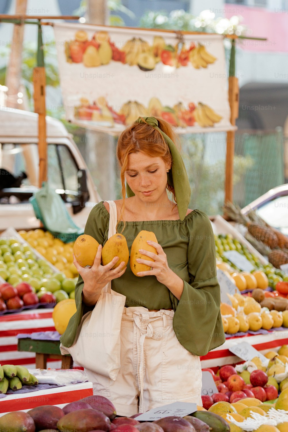 a woman standing in front of a display of fruit
