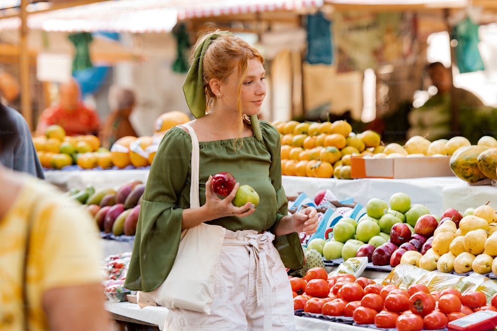 Una mujer parada frente a un puesto de frutas