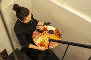 a woman is holding a platter of food
