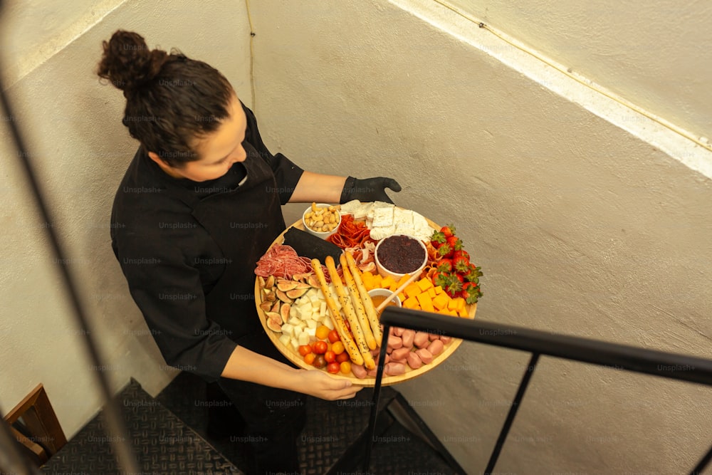 Eine Frau hält eine Platte mit Essen in der Hand