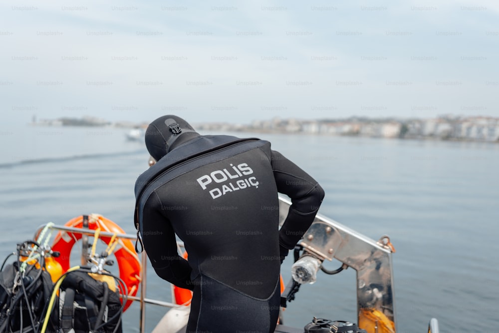 a man in a wet suit standing on a boat