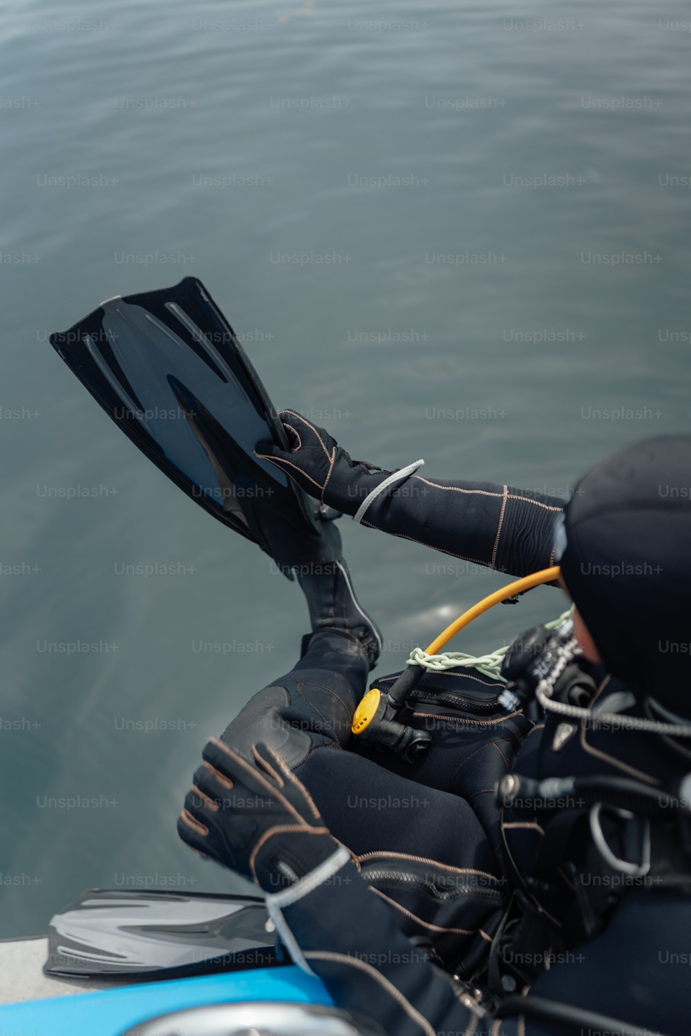 uma pessoa em um traje de mergulho está segurando uma máscara de mergulho